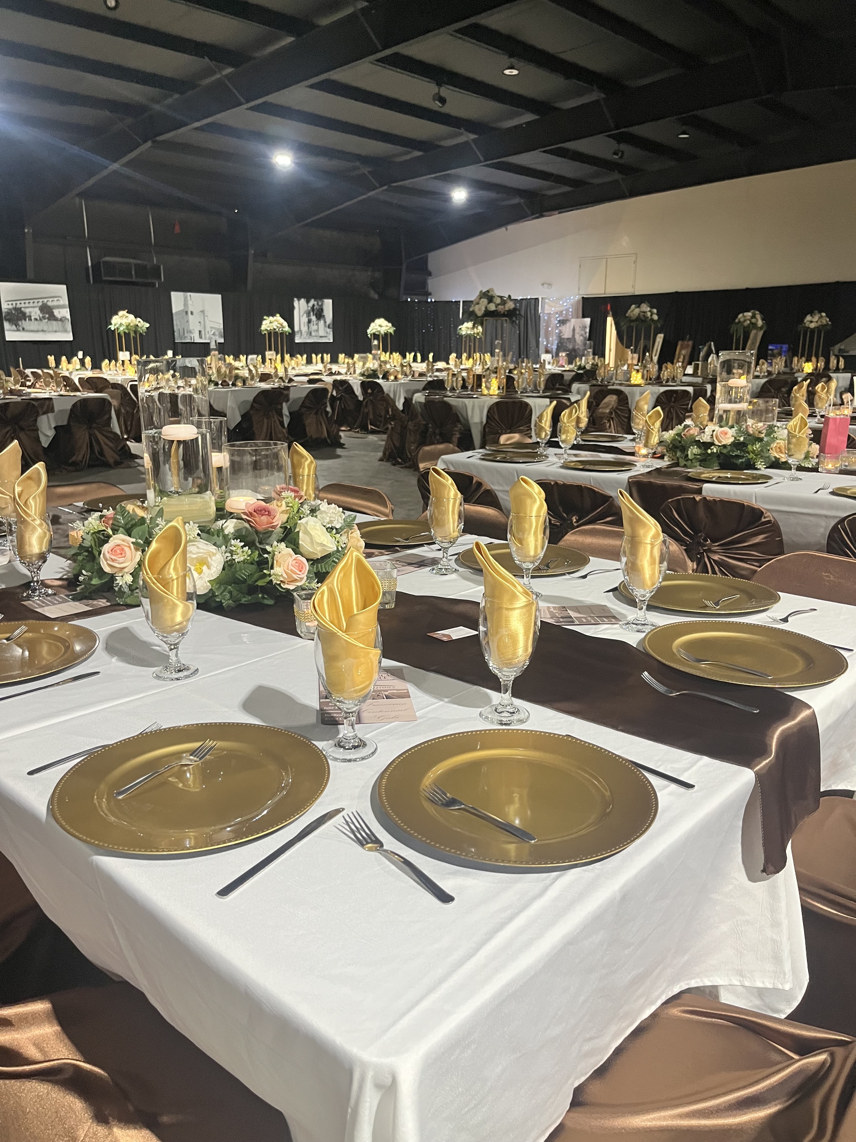 Formal table settings with gold place settings and floral centerpieces
